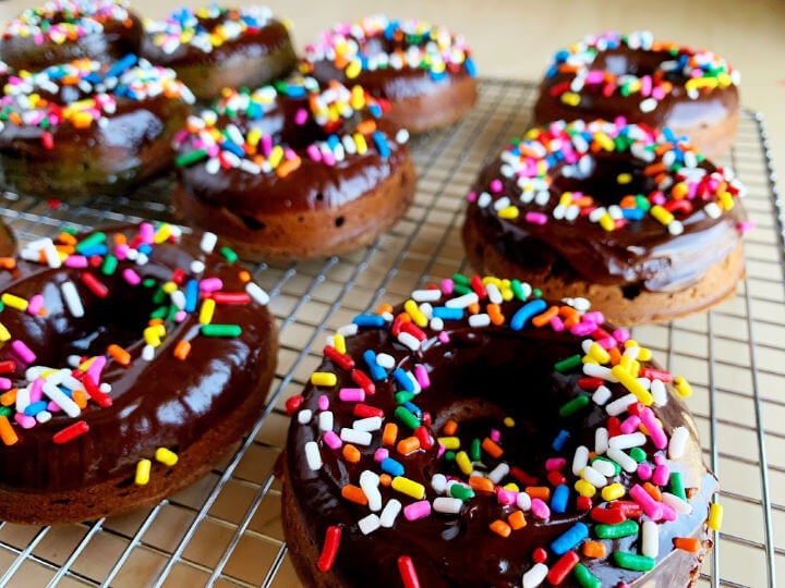 chocolate mochi donuts with sprinkles on rack