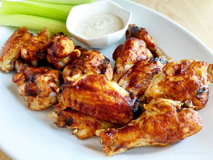 bbq wings, celery sticks, and dip on a plate