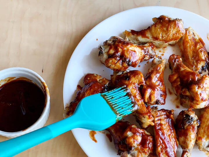 brushing bbq sauce onto wings