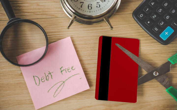 debt free on post it not and scissors cutting credit card