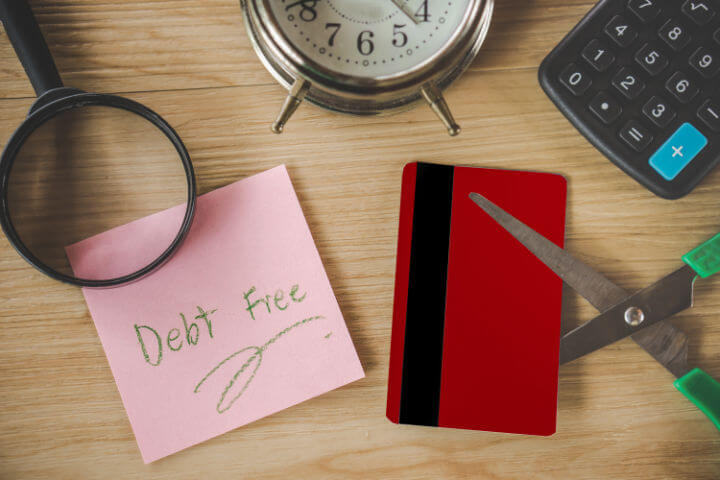 debt free on post it not and scissors cutting credit card