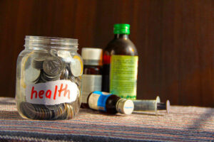 glass jar labeled heath with 3 medicine bottles on a table