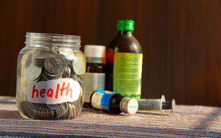 glass jar labeled heath with 3 medicine bottles on a table