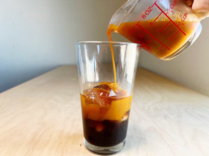 pouring thai iced tea into a glass