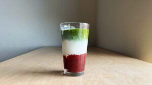 3 layered raspberry matcha latte in a glass cup