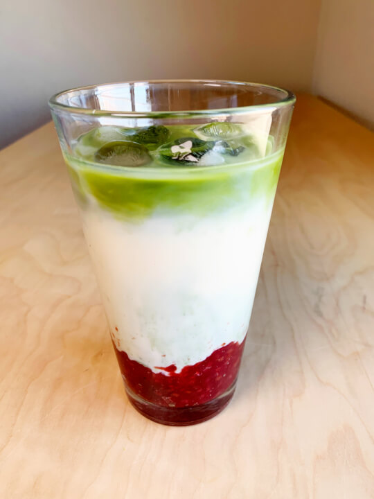 3 layered raspberry matcha latte in a glass cup