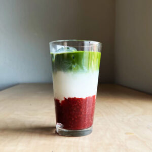 3 layered raspberry matcha latte in a glass cup