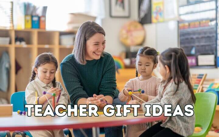 teacher smiling and sitting at table with 3 students