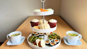 3 tier cake stand with asian food items and 2 cups of tea