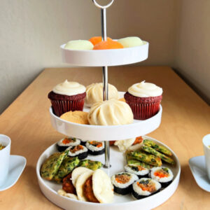 3 tier cake stand with asian food items and 2 cups of tea
