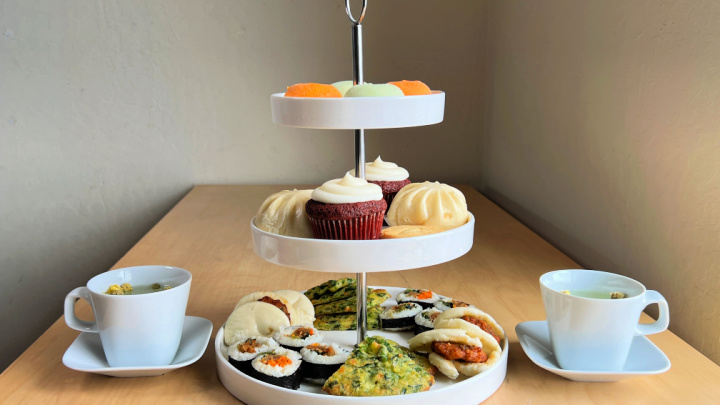 afternoon tea 3 tier stand with asian food items and 2 cups of tea