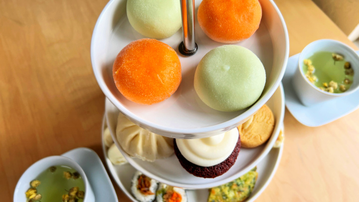 afternoon tea 3 tier stand with asian food items and 2 cups of tea
